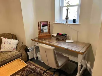 a room with a desk with a chair and a mirror at The Hive in St Austell