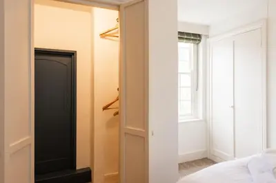 a bedroom with a closet with a black door at The Manor House in Port Isaac