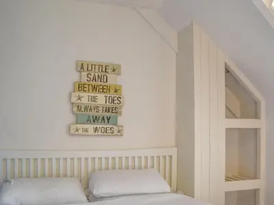 a bedroom with two beds and a sign on the wall at Crantock House in Newquay