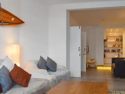 a living room with a white couch and a table at Crantock House in Newquay