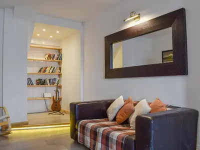 a living room with a couch with a mirror on the wall at Crantock House in Newquay