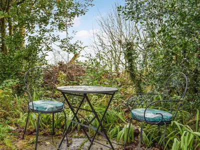 two chairs and a table and a table and chairs at Field View in St Austell