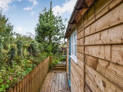 a house with a wooden walkway next to a building at Field View in St Austell