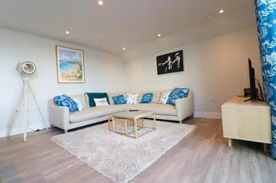 a living room with a couch and a table at Stylish estuary view apartment in Padstow