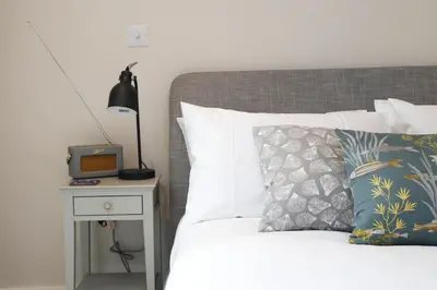 a bedroom with a bed with a nightstand and a bed sidx sidx at Stylish estuary view apartment in Padstow