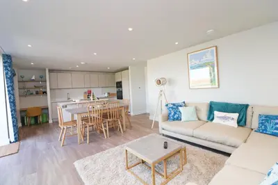 a living room with a couch and a table at Stylish estuary view apartment in Padstow