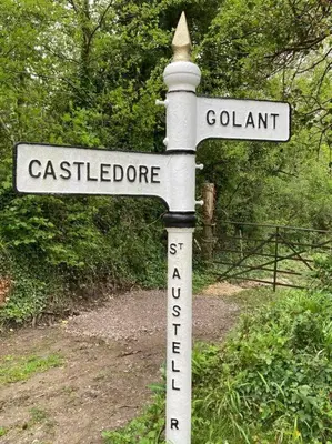 a pole with two street signs on top of it at Stunning River Views, Tranquil Split-Level House, Private Garden & Parking in Golant