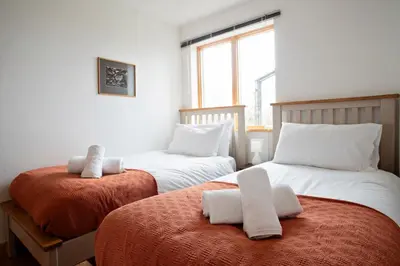 a bedroom with two beds with towels on them at Beautiful Cornish Home 