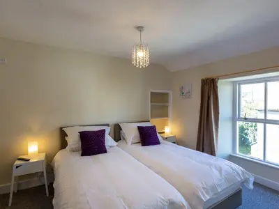 a bedroom with two beds and a window at Ayr Farmhouse in St Ives