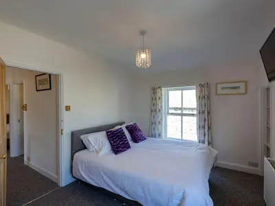 a bedroom with a bed with purple pillows on it at Ayr Farmhouse in St Ives