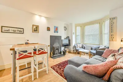 a living room with a couch and a table at Captain's House Looe in Looe