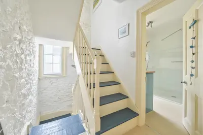 a staircase in a house with a shower and a bathroom at Captain's House Looe in Looe