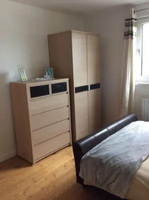 a bedroom with a dresser and a bed and a cabinet at Hibiscus house in Newquay