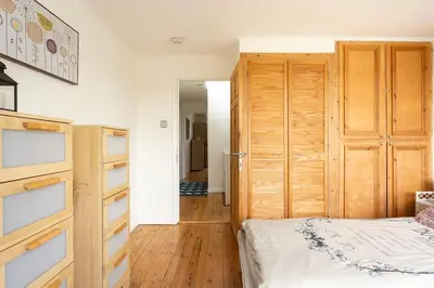 a bedroom with a bed and a wooden closet at Hibiscus house in Newquay