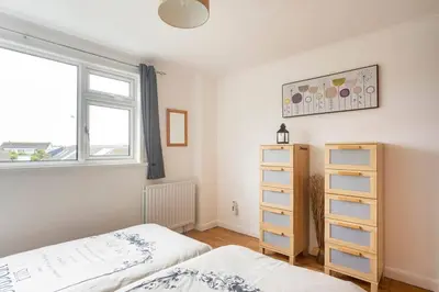 a bedroom with two beds and a window at Hibiscus house in Newquay