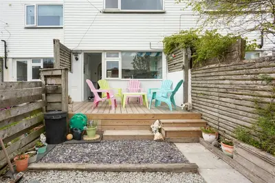 a group of chairs sitting on a wooden deck at Hibiscus house in Newquay