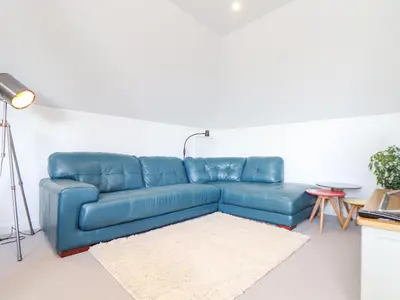 a blue couch in a living room with a table at Higher Bolenna in Perranporth