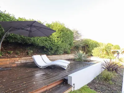 a couple of chairs and an umbrella on a deck at Higher Bolenna in Perranporth
