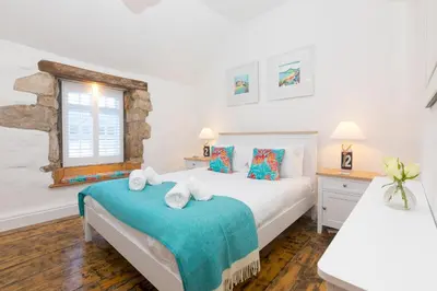 a bedroom with two beds and a window at 20 The Warren in St Ives