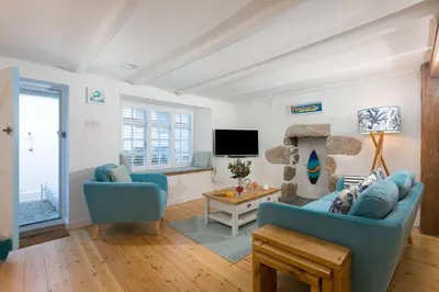 a living room with a blue couch and a tv at 20 The Warren in St Ives