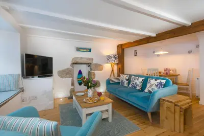a living room with a blue couch and a table at 20 The Warren in St Ives