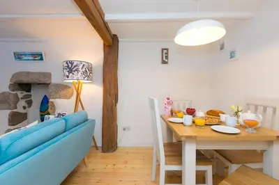 a living room with a table and a blue couch at 20 The Warren in St Ives