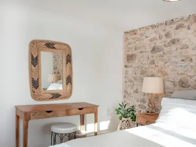 a bedroom with a bed and a mirror on the wall at Harlequin Cottage in St Austell