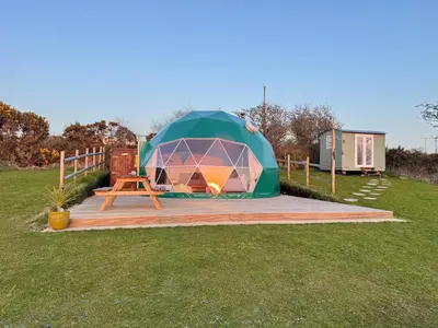 a tent in a field with a picnic table at Sunset Ridge - Luxury Geodesic Dome set in the beautiful countryside in Porkellis