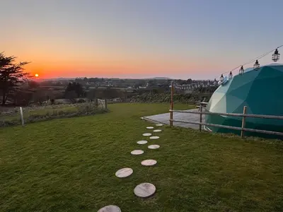 a group of rocks on the grass in a field at Sunset Ridge - Luxury Geodesic Dome set in the beautiful countryside in Porkellis
