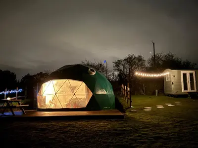 a tent with a light in a field at night at Sunset Ridge - Luxury Geodesic Dome set in the beautiful countryside in Porkellis