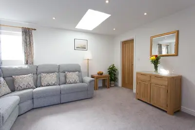 a living room with a couch and a table at Cornish Views in Camborne