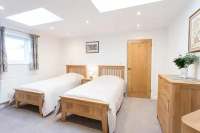 two twin beds in a room with a window at Cornish Views in Camborne