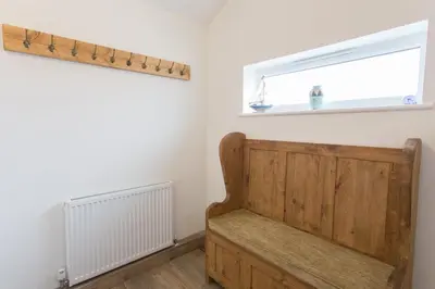 a room with a wooden bench and a window at Cornish Views in Camborne