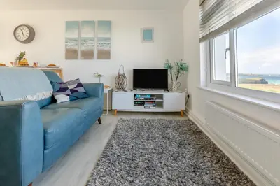 a living room with a blue couch and a television at 2 Bed in Newquay oc-a28105 in Newquay