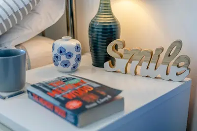 a bedside table with books and vases on it at 2 Bed in Newquay oc-a28105 in Newquay