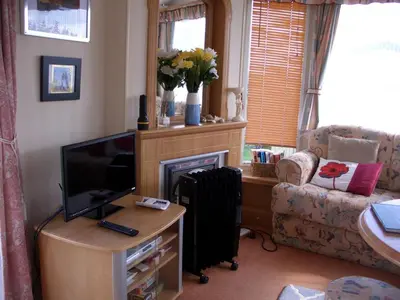 a living room with a television and a couch at Colin and annioes caeravan in Looe
