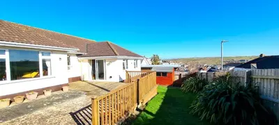 a house with a wooden fence in a yard at Trenare in Perranporth