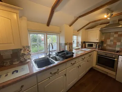 a kitchen with a sink and a counter top at Lilac Cottage Tintagel in Tintagel