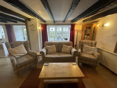 a living room with a couch and chairs and a table at Lilac Cottage Tintagel in Tintagel