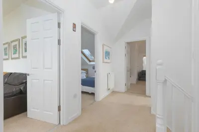 a hallway with white doors and a bedroom at Polmoor in St Ives