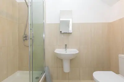 a bathroom with a sink and a toilet and a shower at Polmoor in St Ives