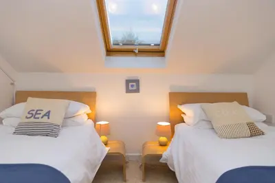 two beds in a small room with a window at Polmoor in St Ives