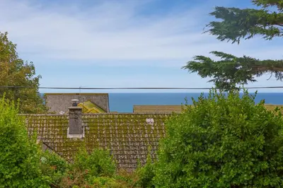 a brick fence with the ocean in the background at Polmoor in St Ives