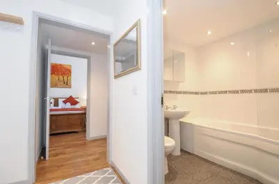 a bathroom with a tub and a toilet and a sink at Lambley View in Bude