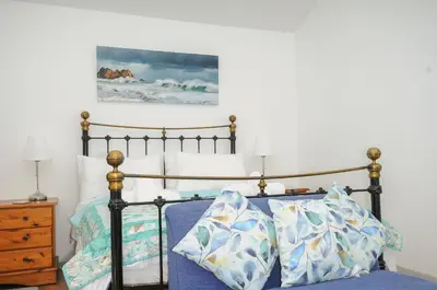 a bedroom with a bed with blue sheets and pillows at Lambley View in Bude