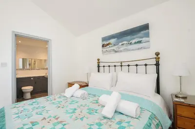 a bedroom with a large bed with white pillows at Lambley View in Bude