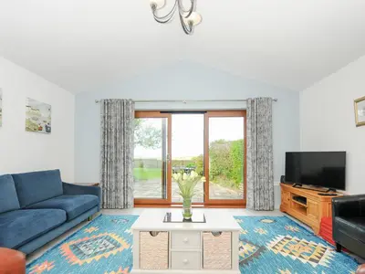 a living room with a blue couch and a tv at Lambley View in Bude