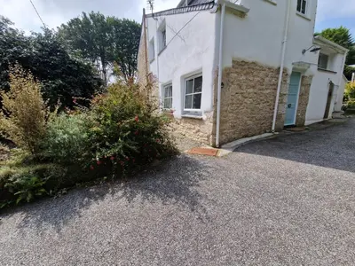 a house with a driveway in front of it at Primrose Cottage in Helston