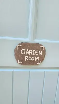 a sign on a door that says garden room at Primrose Cottage in Helston