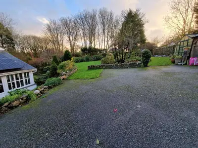 an empty driveway in a yard with a house at Primrose Cottage in Helston